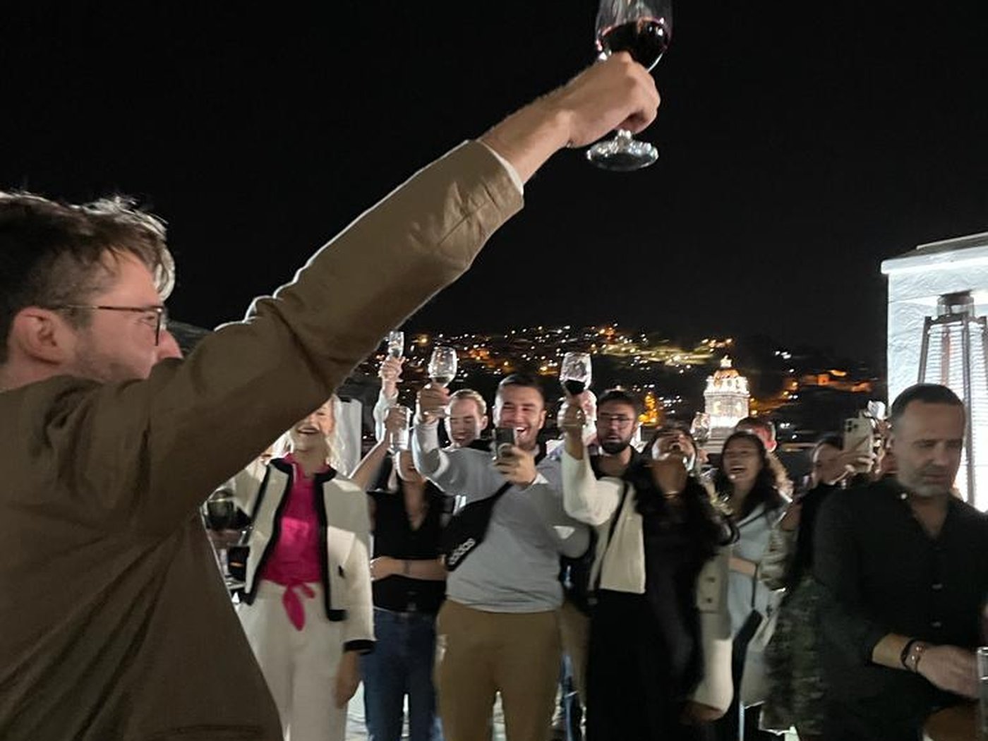 A toast above the lights of the historic center