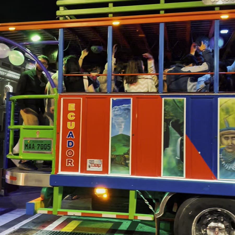 Guests aboard an illuminated chiva through Quito